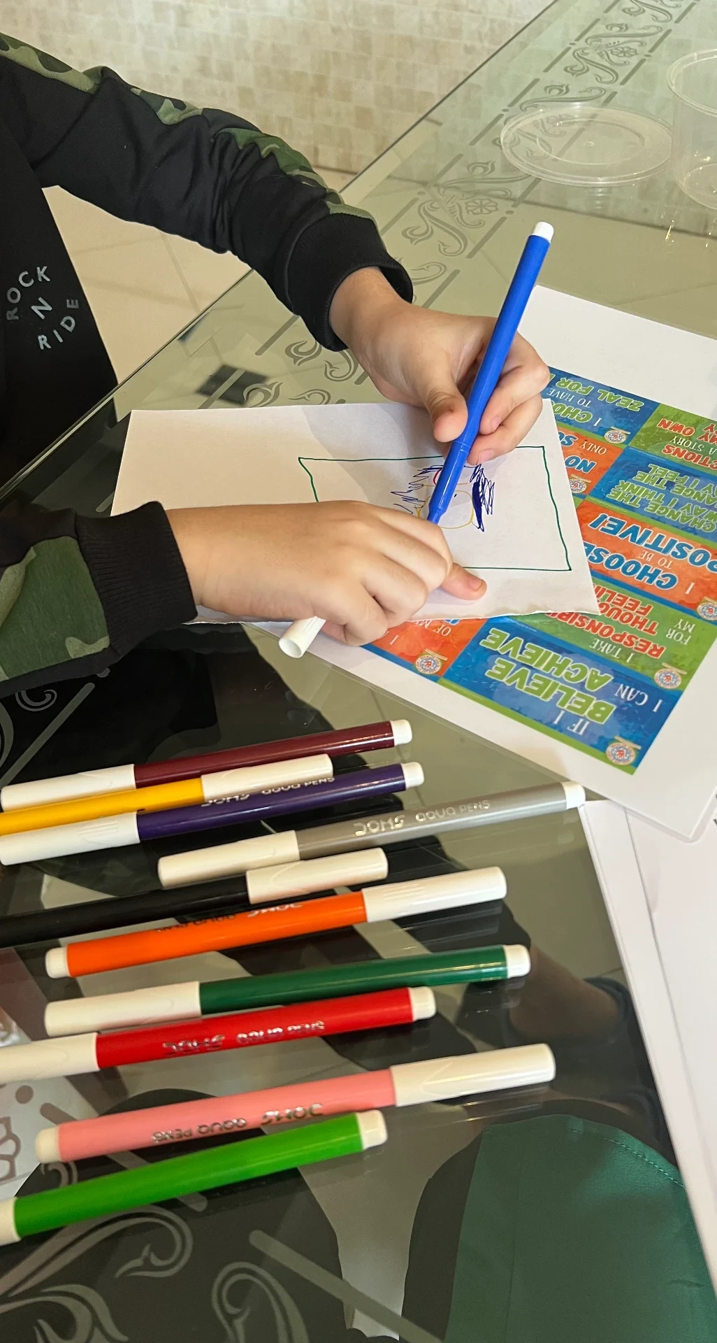 Hands using coloured pens during a creative perspective exercise.